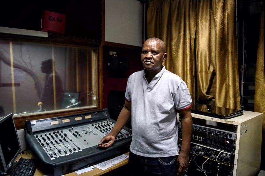 Léon Masengo, editor en jefe de Radio Bonesha FM, posa en su estudio el 15 de mayo de 2015 después de que fuera incendiado y saqueado por las fuerzas de seguridad, dos días antes, tras un intento de golpe de Estado. | Fuente: Jennifer Huxta/AFP